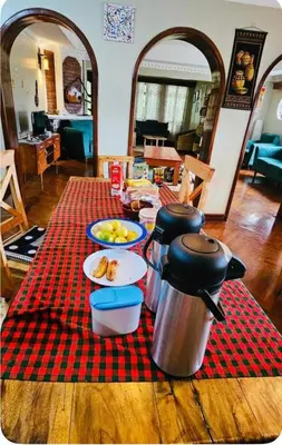 a table with food on a red checked table cloth at Tropical Garden Homestay in Arusha