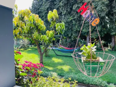a yard with a hammock and a tree with flowers at Tropical Garden Homestay in Arusha