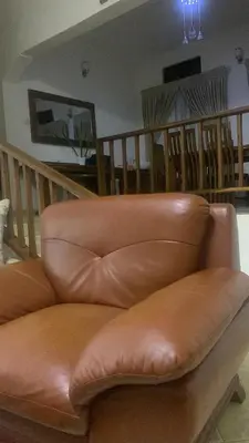 a brown leather couch sitting in a living room at Aa peaceful resting home in Karatu