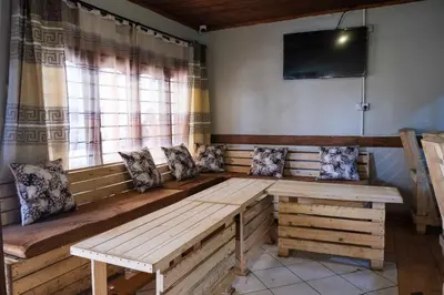 a wooden bench in a room with a window at Seuri Bar and Guesthouse in Arusha