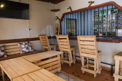 a bar with wooden chairs and a wooden table at Seuri Bar and Guesthouse in Arusha