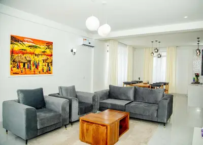 a living room with two couches and a table at Smile Apartments Arusha in Arusha