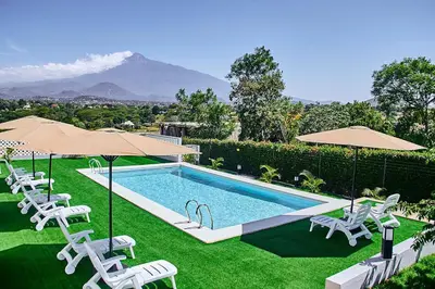 a swimming pool with chairs and umbrellas at Smile Apartments Arusha in Arusha