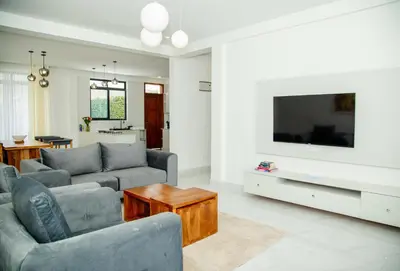 a living room with a couch and a tv at Smile Apartments Arusha in Arusha