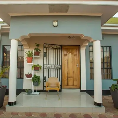 a front door of a house with a chair at MD Apartments in Arusha