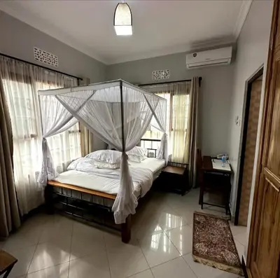 a bedroom with a bed with a canopy at MD Apartments in Arusha
