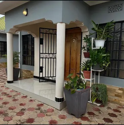 a front door of a house with potted plants at MD Apartments in Arusha