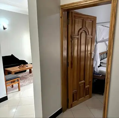 an open door to a room with a bedroom at MD Apartments in Arusha