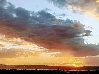 a cloudy sky with the sun setting in the background at Anapa Lodge and Camp in Mto wa Mbu
