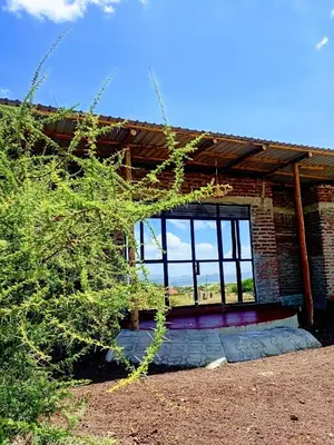 a brick building with a window on the side of it at Anapa Lodge and Camp in Mto wa Mbu