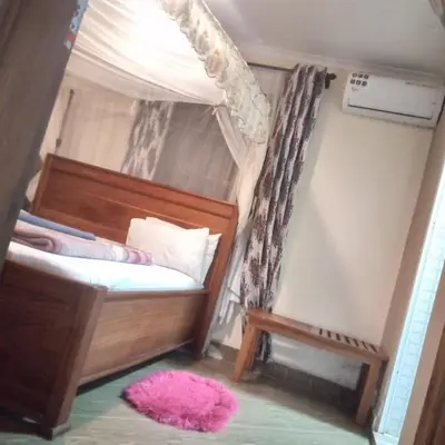a bedroom with a bunk bed with a pink rug at SEELA CLASSIC LODGE-Mbauda Arusha Tanzania in Arusha
