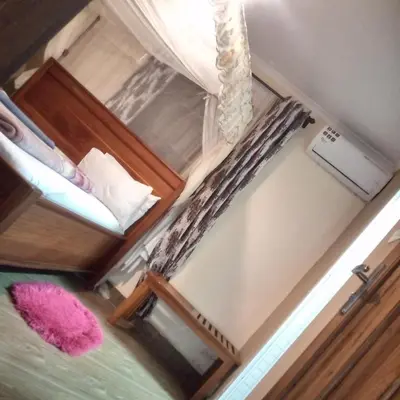 a small room with a bed and a window at SEELA CLASSIC LODGE-Mbauda Arusha Tanzania in Arusha