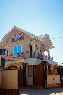 a large white building with a balcony on it at SEELA CLASSIC LODGE-Mbauda Arusha Tanzania in Arusha