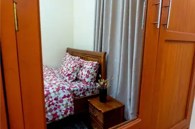 a chair with pillows sitting in front of a window at Elite Homes in Arusha