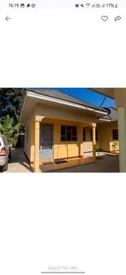 a yellow house with a car parked in front of it at Elite Homes in Arusha