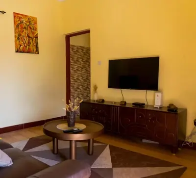a living room with a tv and a coffee table at Elite Homes in Arusha
