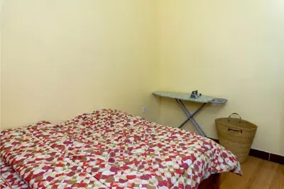 a bedroom with a bed with a flowered blanket at Elite Homes in Arusha