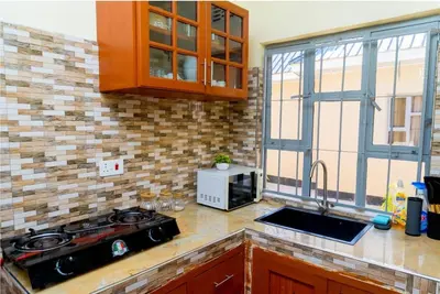 a kitchen with a stove and a sink and a window at Elite Homes in Arusha