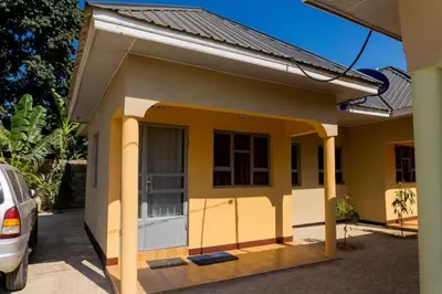 a small house with a car parked in front of it at Elite Homes in Arusha