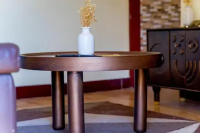 a small wooden table with a vase on top of it at Elite Homes in Arusha
