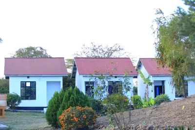 a white house with a red roof at Mlangoni Cottages in Sanya Juu