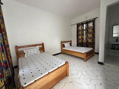 a bedroom with two beds and a window at Mlangoni Cottages in Sanya Juu