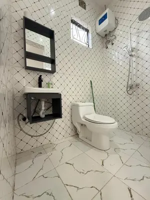 a bathroom with a toilet and a sink and a mirror at Mlangoni Cottages in Sanya Juu