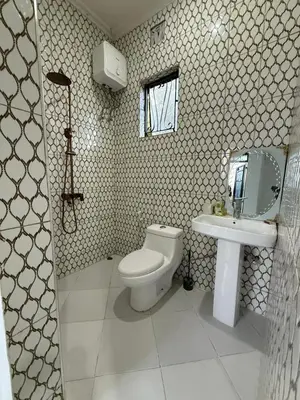 a bathroom with a toilet and a sink at Mlangoni Cottages in Sanya Juu