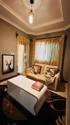 a living room with a bed and a couch at Sanplay Homes in Arusha
