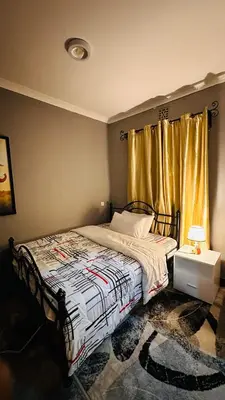 a bedroom with a bed and a window at Sanplay Homes in Arusha