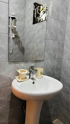a bathroom with a sink with two cups on it at Sanplay Homes in Arusha