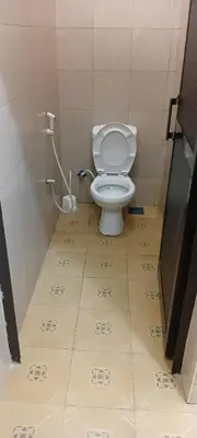 a small bathroom with a toilet in a stall at Friendly House in Arusha