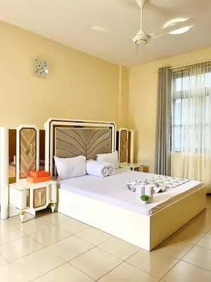 a bedroom with a large white bed in a room at Apartment in Arusha City Centre AICC in Arusha
