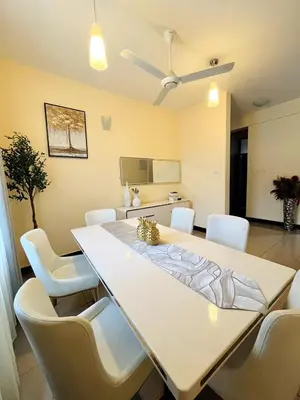 a dining room with a white table and white chairs at Apartment in Arusha City Centre AICC in Arusha