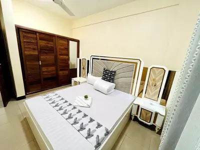 a large white bed in a room with a window at Apartment in Arusha City Centre AICC in Arusha