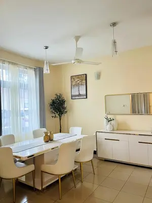 a dining room with a table and white chairs at Apartment in Arusha City Centre AICC in Arusha
