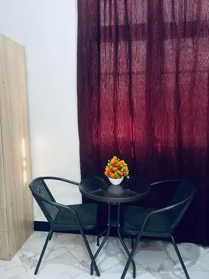 a table and chairs with a bowl of flowers on it at Osim Bnb in Arusha