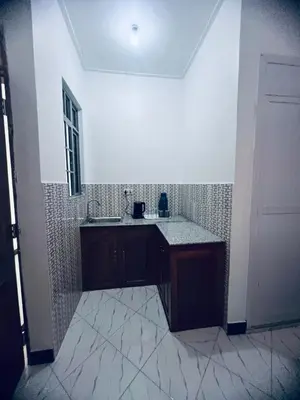 a bathroom with a sink and a tile wall at Osim Bnb in Arusha