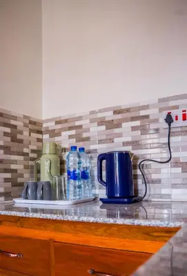a counter top with bottles of water and a toaster at Osim Bnb in Arusha