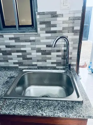 a stainless steel sink with a faucet in a kitchen at Osim Bnb in Arusha