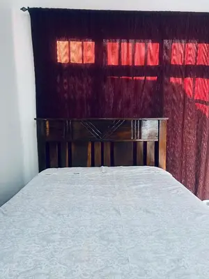 a bedroom with a bed and a red curtain at Osim Bnb in Arusha