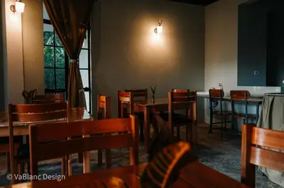 a dining room with tables and chairs and a bar at Naishika Home Stay in Tengeru