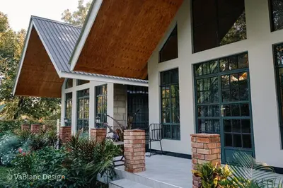 a house with a porch with windows and a roof at Naishika Home Stay in Tengeru