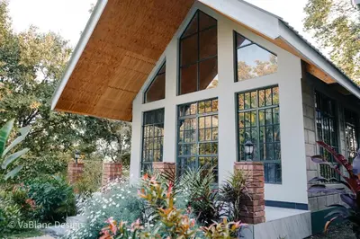 a house with large windows and a porch at Naishika Home Stay in Tengeru