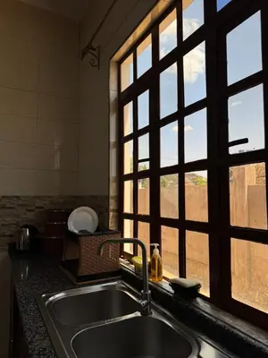 a kitchen with a sink and a window at Oasis HomeStay in Arusha