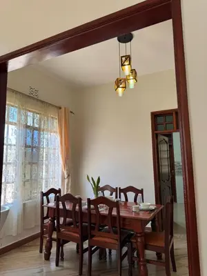 a dining room with a table and chairs and a mirror at Oasis HomeStay in Arusha