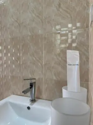 a bathroom with a sink and a toilet with a paper at Oasis HomeStay in Arusha