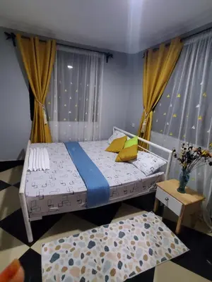 a small bedroom with a bed and a table at divine favour homestay in Arusha