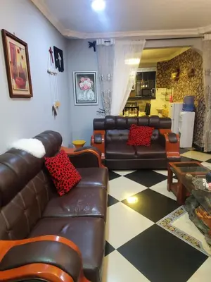 a living room with leather furniture and a checkered floor at divine favour homestay in Arusha