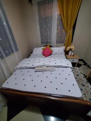 a bedroom with a bed with black and white sheets at divine favour homestay in Arusha